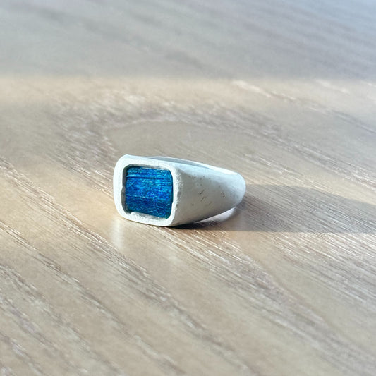 Artisan silver ring featuring a naturally iridescent peacock feather with a softly shifting ocean blue hue, by Cici Dream