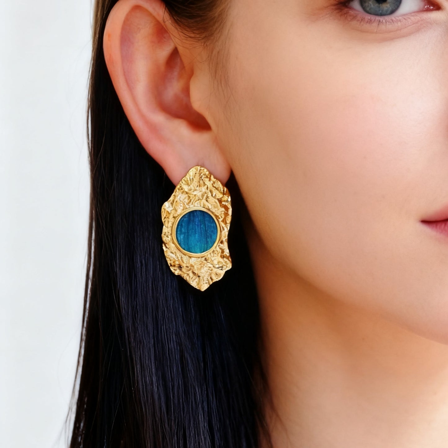 Aurelia Crest Peacock Feather Earrings worn by a person against a white background