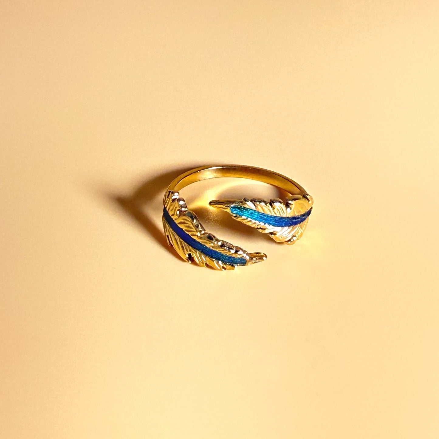 Echo Feather Open Spiral Ring by Cici Dream with iridescent colours shifting in light.