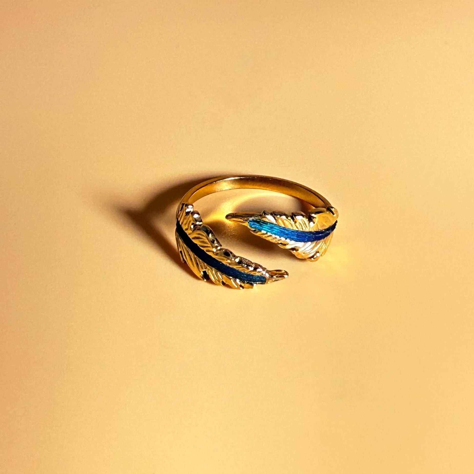 Echo Feather Open Spiral Ring by Cici Dream with iridescent colors shifting in light.