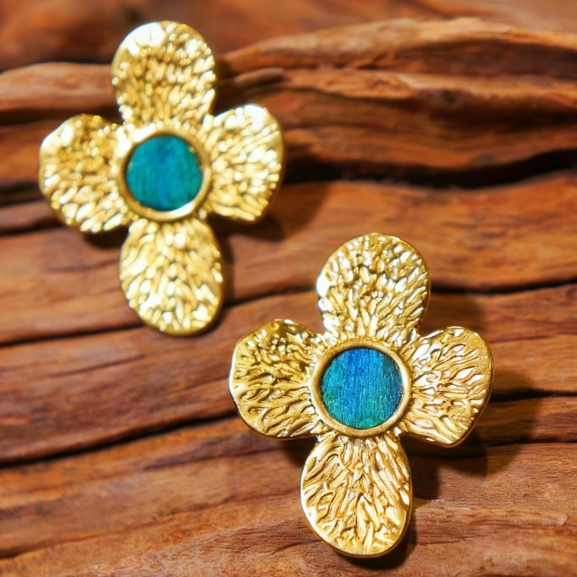 Isla Clover Four-Petal Peacock Feather Earrings from Cici Dream on a wooden surface