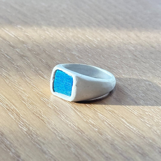Artisan silver ring featuring a naturally iridescent peacock feather shifting from bright teal to royal blue, by Cici Dream